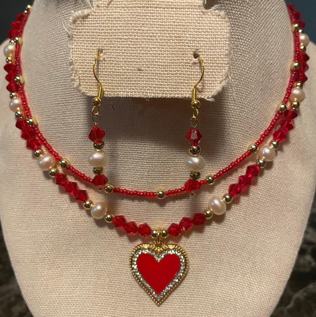 Jewelry set with red and pearl necklace and earrings on a mannequin bust.