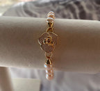 freshwater pearl bracelet on display with gold flower clasp